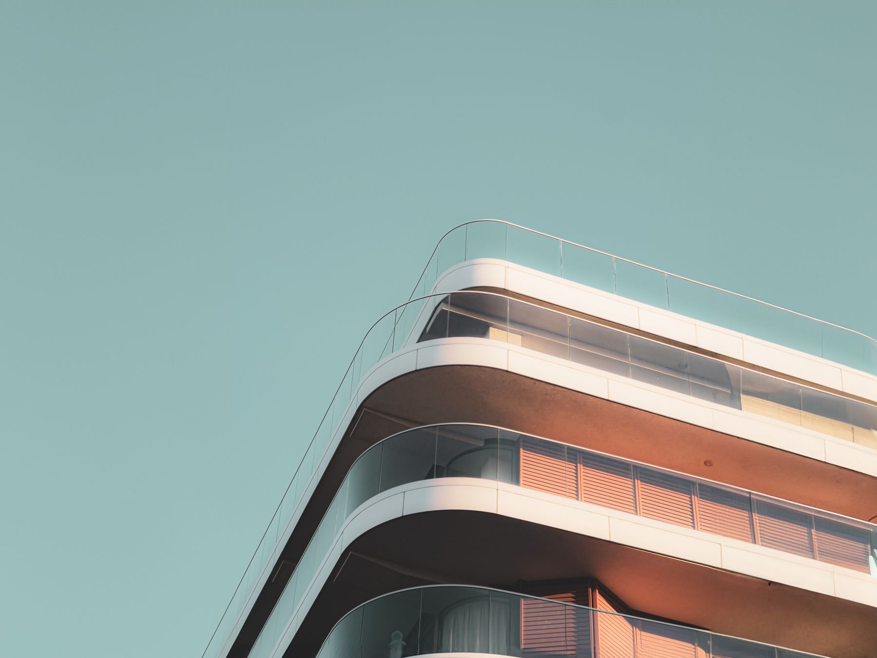 Edificio contemporáneo de balcones curvos iluminado por el sol